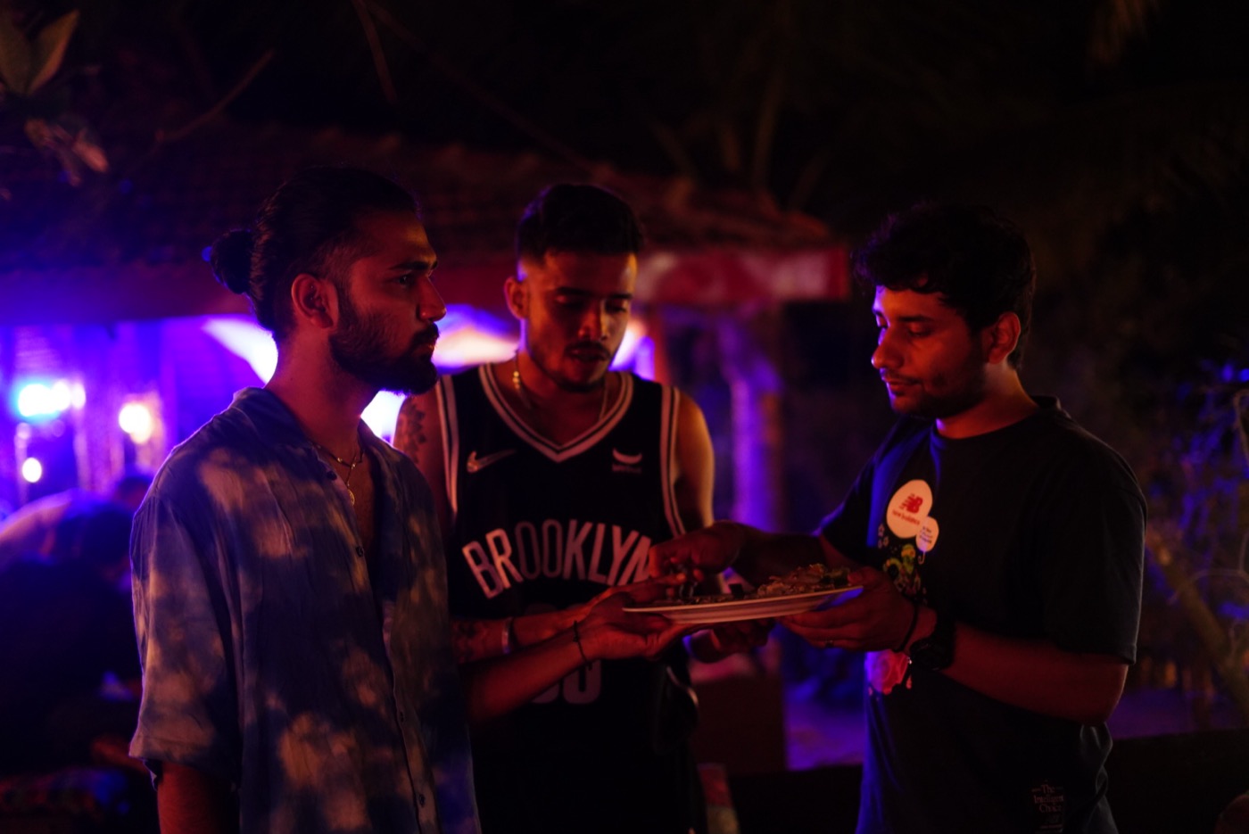 Three team members sharing food at an evening event