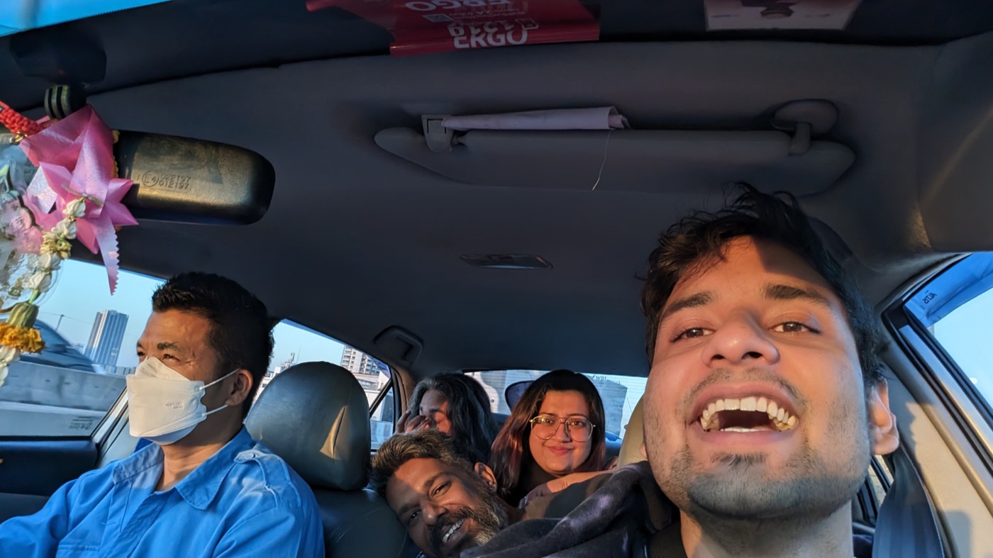 A crowded and cheerful team selfie inside a car